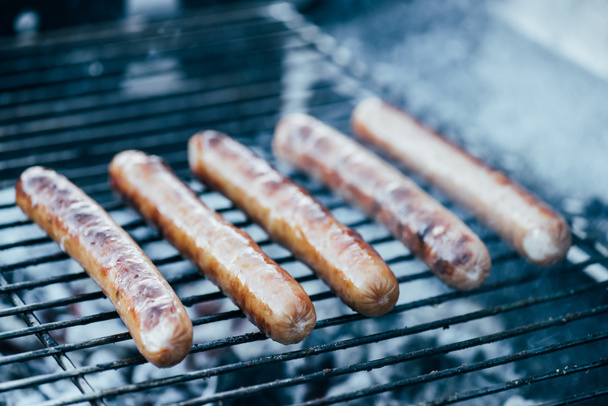 selective focus of tasty grilled sausages on bbq grill grade - Foto, afbeelding