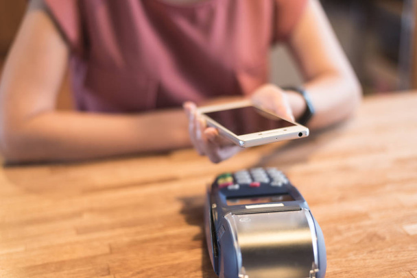 femme payant avec la technologie NFC par un smartphone
 - Photo, image