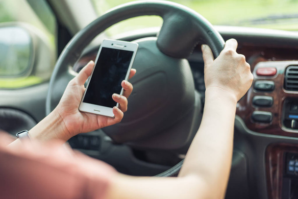 women driver with a cell phone in hand while driving - Foto, imagen