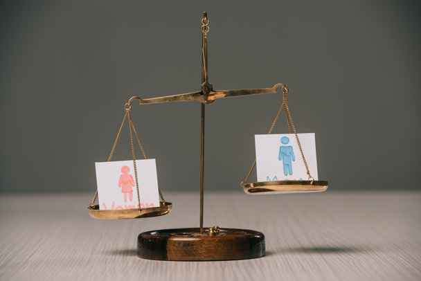 férfi és női jel a mérleg a fából készült asztal, nemek közötti egyenlőség fogalma - Fotó, kép