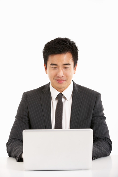 Studio Shot Of Chinese Businessman Working On Laptop - Photo, image