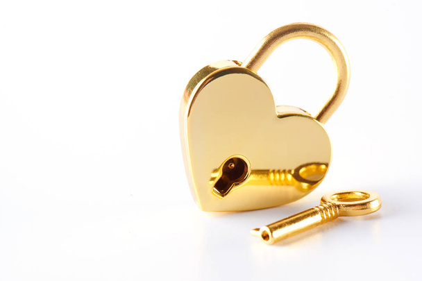 Golden lock with a key on a white background. Love concept St. Valentine's Day - Photo, Image