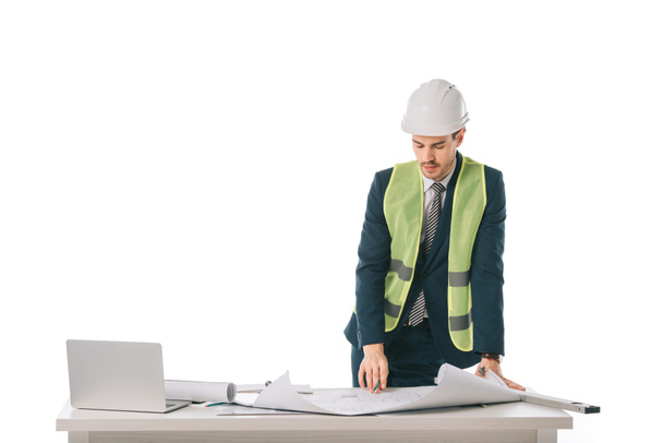 arquitecto masculino en casco y chaleco de seguridad trabajando con planos y portátil, aislado en blanco
 - Foto, Imagen