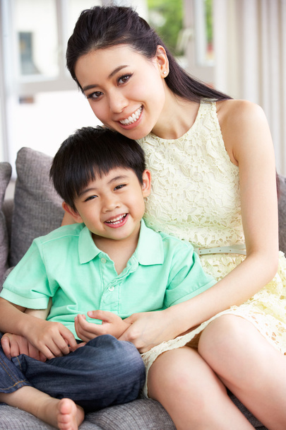 Chinese Mother And Son Sitting On Sofa At Home Together - Foto, afbeelding