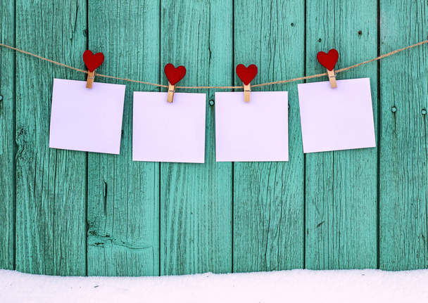 Čtyři prázdné fotografie visí na laně clothespins s srdcem - Fotografie, Obrázek