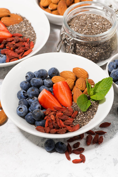 chia seeds, fresh berries and nuts for a healthy breakfast, closeup - Foto, imagen