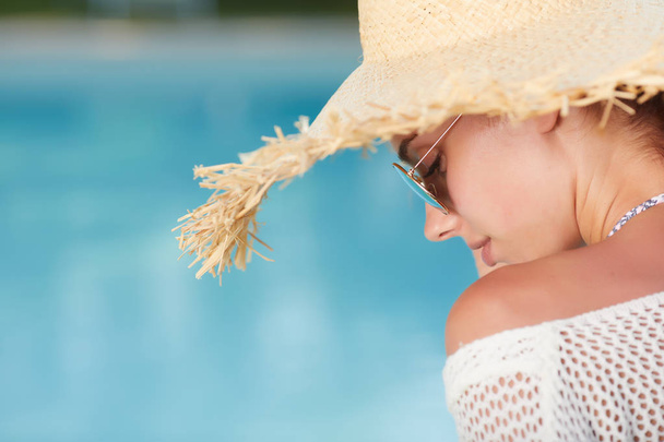 Moda hermosa mujer en vacaciones de verano relajante en el balneario de lujo junto a la piscina. Joven dama de moda con sombrero de sol
  - Foto, imagen