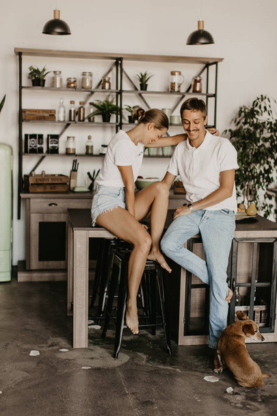 Beautiful loving couple laughing and hugging in the kitchen - Foto, Bild