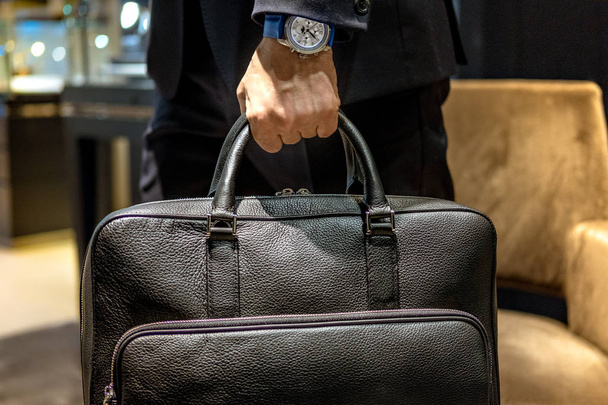 Vista parcial del hombre que lleva el maletín de cuero negro
 - Foto, Imagen