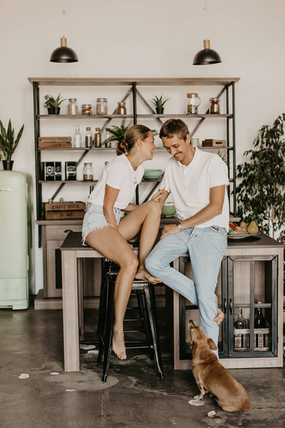 Beautiful loving couple laughing and hugging in the kitchen - Foto, afbeelding