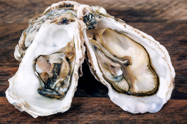 fresh open oysters on wooden background - Foto, Bild