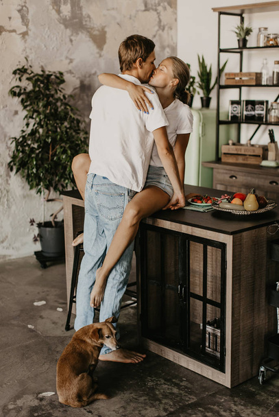 Beautiful loving couple kisses and hugs in the kitchen - Φωτογραφία, εικόνα