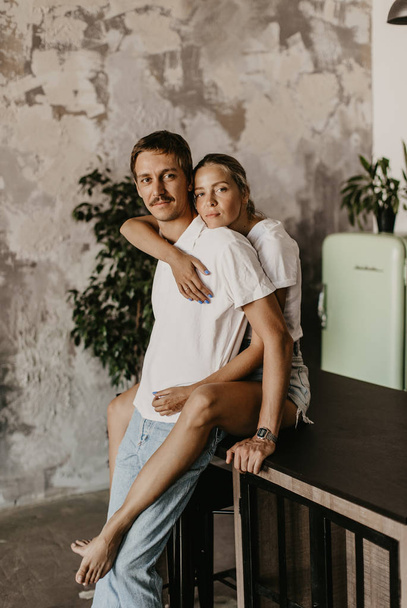Beautiful loving couple kisses and hugs in the kitchen - Fotografie, Obrázek