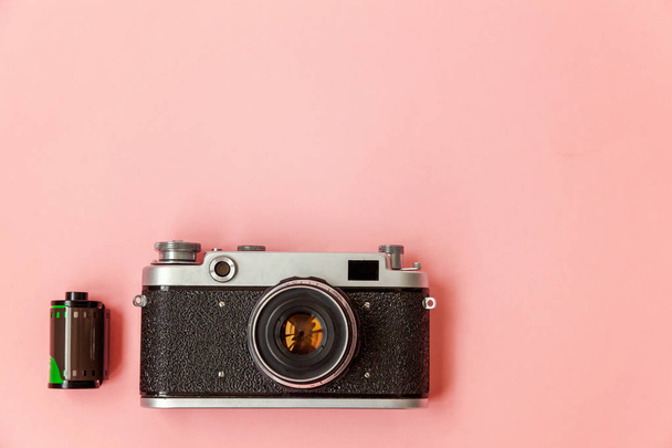Teknoloji geliştirme hipster fotoğrafçı hobi klasik bellek gezi konsepti. Vintage film fotoğraf kamera lensi ve pembe pastel trendy modern moda pin-up arka plan üzerinde film rulo - Fotoğraf, Görsel