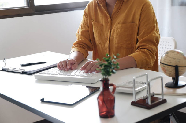 Detail z ženských rukou. Žena v neformální hadřík práce, psaní na klávesnici ve své kanceláři. - Fotografie, Obrázek