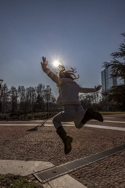 Girl jumping on contre jour sun - Фото, зображення