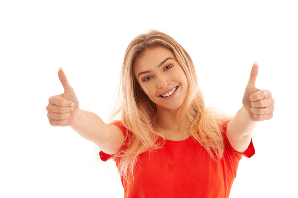 Beautiful young woman in red t shirt gesture success with showing thumbs up isolated over white - Foto, Imagem