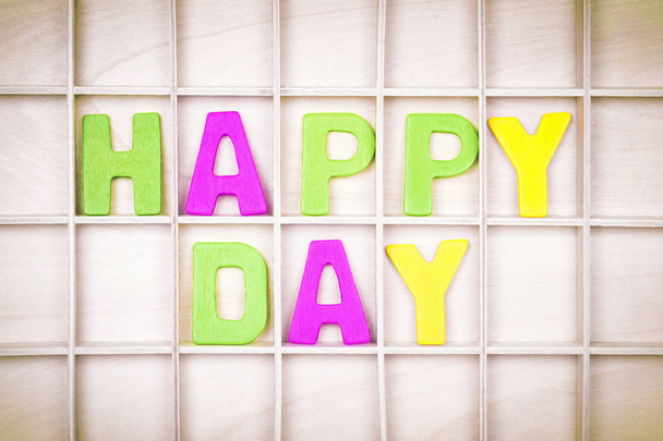 Happy day text from colorful letters is on wooden board. - Foto, Bild