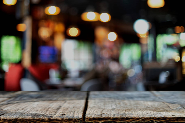 wooden table in front of the blur background with bokeh light in the coffee shop or restaurant - Foto, imagen