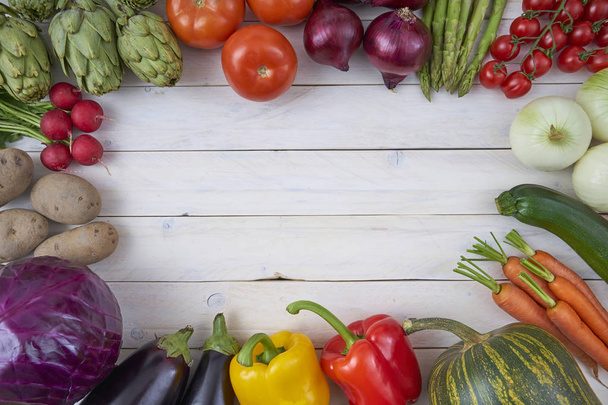 Vista superior de legumes para cartazes e menus de comida saudável em fundo de madeira branca. Produtos agrícolas biológicos. Comida Vegan. Vegetais. Produtos hortícolas frescos
 - Foto, Imagem