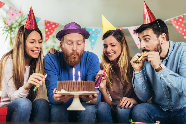 Grupa młodych przyjaciół happy obchodzi urodziny w domu i zabawy. - Zdjęcie, obraz