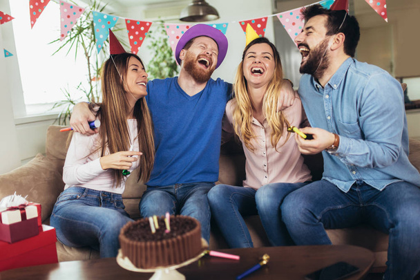 Молода група щасливих друзів святкують день народження вдома і розважаються
. - Фото, зображення