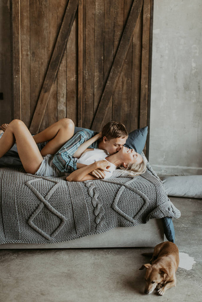 Beautiful couple in love laughs and kisses on the bed - Fotoğraf, Görsel