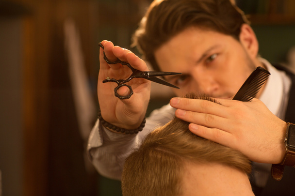 Selective focus on the hands of a professional barber using scissors and a comb cutting hair of his client copyspace service hairdresser barbershop stylist hairstyling profession barbering job traditional. - Fotoğraf, Görsel