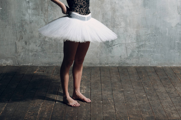 Балерина женщина. Молодая красивая балетная танцовщица, одетая в профессиональный костюм, пуанты и белые балетные пачки
. - Фото, изображение