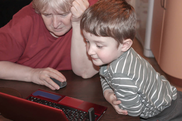 Grandson and grandmother using a computer at home. - Fotoğraf, Görsel
