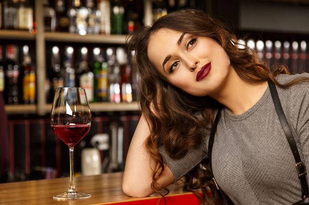 Ben ve hayallerim. Uzak sersem arıyor muhteşem kırmızı dudaklı genç bir kadın portresi barda bir bardak şarap yaparken gülümseyen - Fotoğraf, Görsel