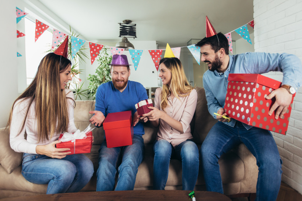Молодая компания счастливых друзей празднует день рождения дома и веселится
. - Фото, изображение