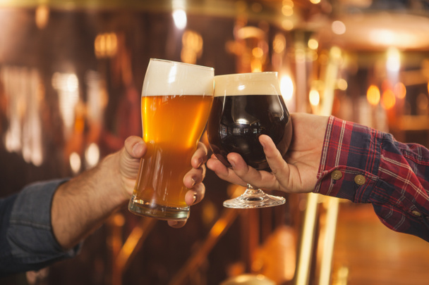 Vágott két férfi csengő szemüveges beer együtt, ünnepli a sör pub közelről. Szakmai sörgyárak sör poharaikat pirítás. Siker megünneplése, oktoberfest fesztivál koncepció - Fotó, kép