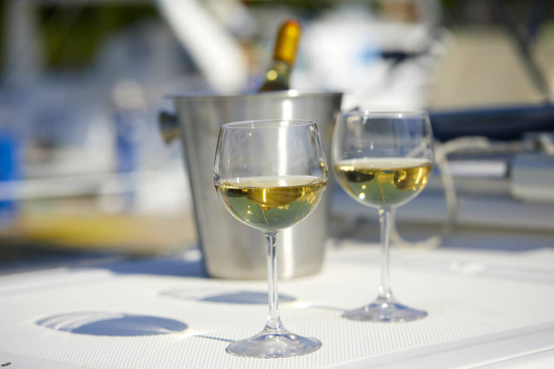 Ζευγάρι wineglasses και κουβά με λευκό κρασί μπουκάλι στο γιοτ - Φωτογραφία, εικόνα