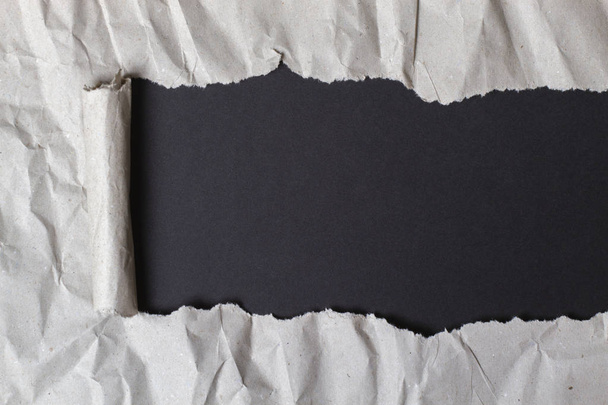 Carta da pacchettizzare strappata con sfondo nero
 - Foto, immagini