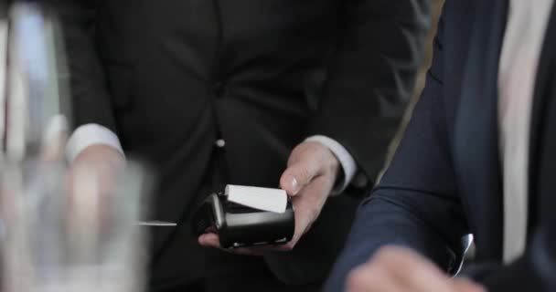 Closeup of businessman paying for meal in a restaurant - Felvétel, videó