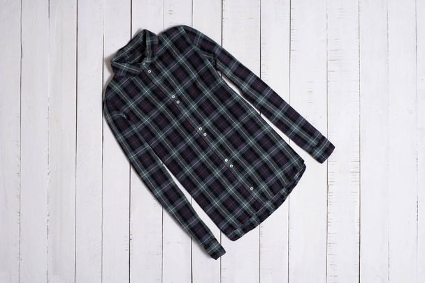 Fashion clothes. Green checkered shirt on white wooden floor planks - Photo, Image