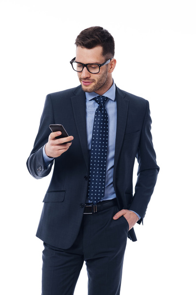Handsome businessman checking emails on the phone - Foto, imagen