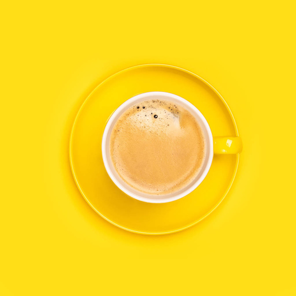 Yellow coffee cup on yellow background, flat lay - 写真・画像