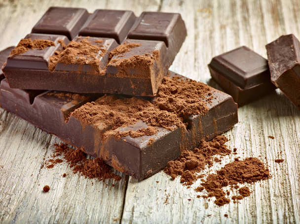 close up de pedaços de chocolate no fundo de madeira - Foto, Imagem