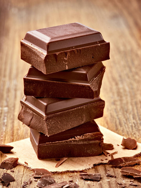 primer plano de piezas de chocolate sobre fondo de madera - Foto, Imagen