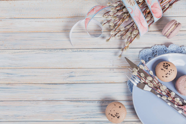 Easter table setting with coffee, macaroon cookies, willow branches and cutlery. Spring holiday concept - Foto, Bild