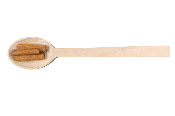 palitos de canela sobre una cuchara de madera aislada sobre fondo blanco
 - Foto, Imagen