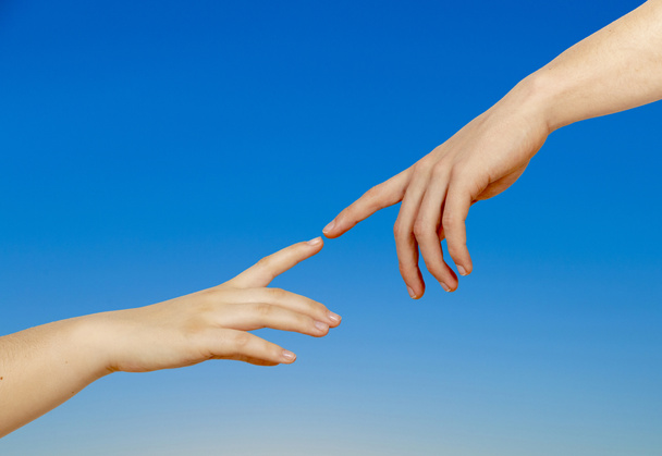 Two hands on a light background, a replica of the plot of Michelangelo's "The Creation of Adam" - Photo, Image