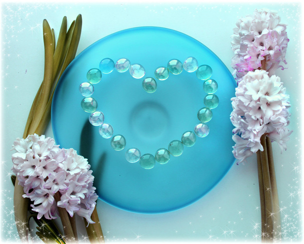 Hyacinth flowers with a heart from pearl beads on blue glass plate - Fotografie, Obrázek