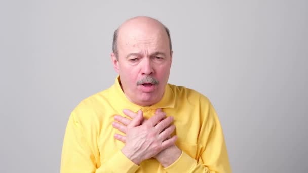 Volwassen Spaanse man in geel t-shirt man hoesten wezen ziek. - Video