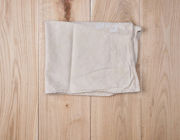toalla blanca doblada sobre fondo de madera marrón, vista superior
 - Foto, imagen