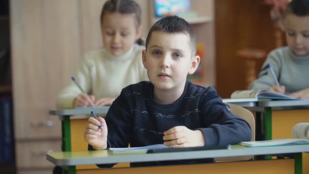 Lapset kirjoittavat työpöydän ääressä.
 - Materiaali, video