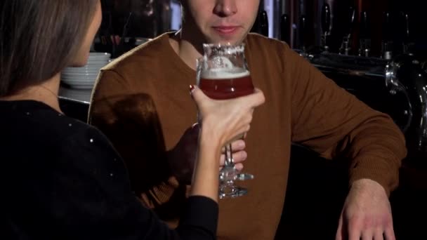 Preciosa pareja tintineando sus vasos de cerveza, celebrando el aniversario en el restaurante
 - Metraje, vídeo