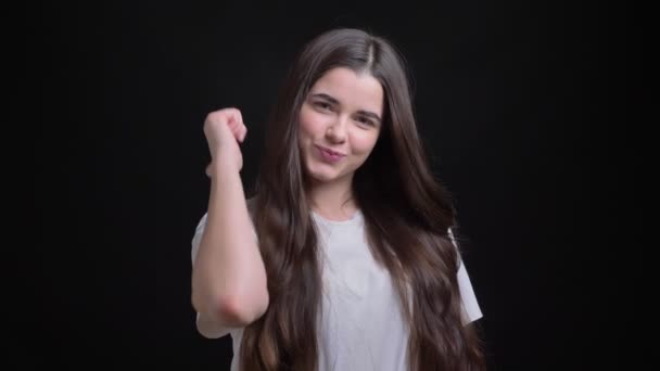 Πορτρέτο της ευτυχισμένος υπέρβαροι μελαχρινή Καυκάσιος κορίτσι χειρονομίες δάχτυλο-up σύνδεσης να δείξει, όπως και τον σεβασμό στην κάμερα σε μαύρο φόντο. - Πλάνα, βίντεο